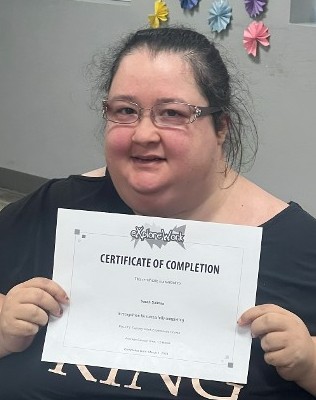 Sarah shows off her Certificate of Completion